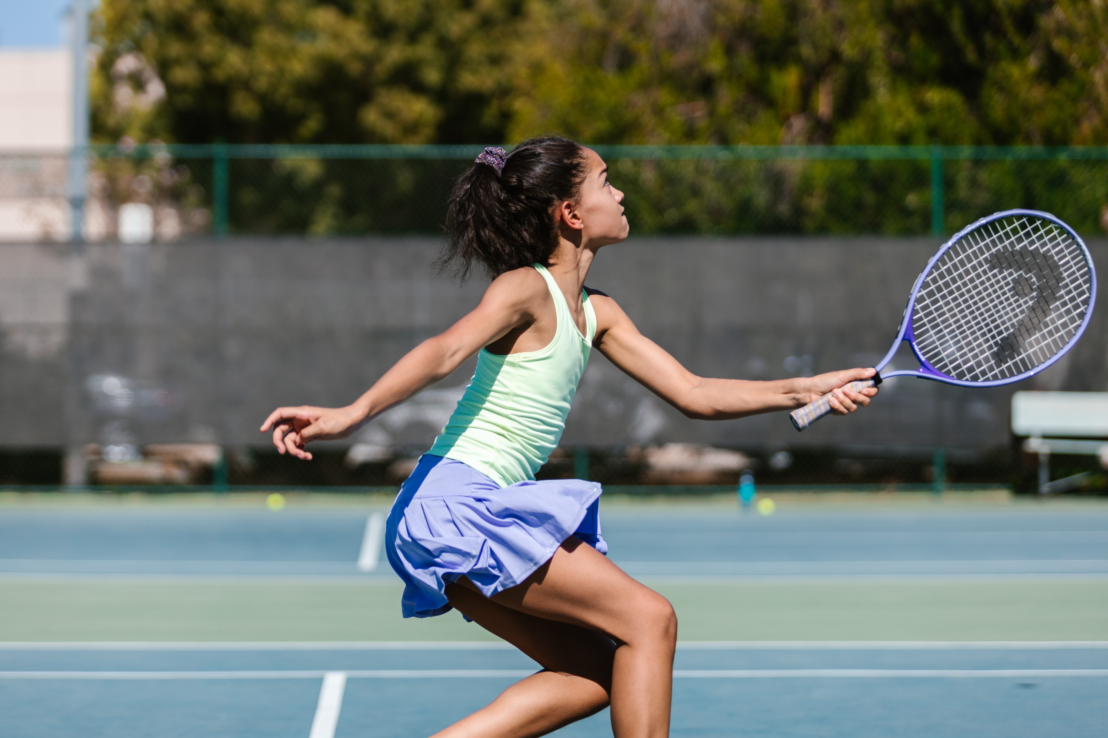 Recreational tennis player mid-stroke on a hardcourt